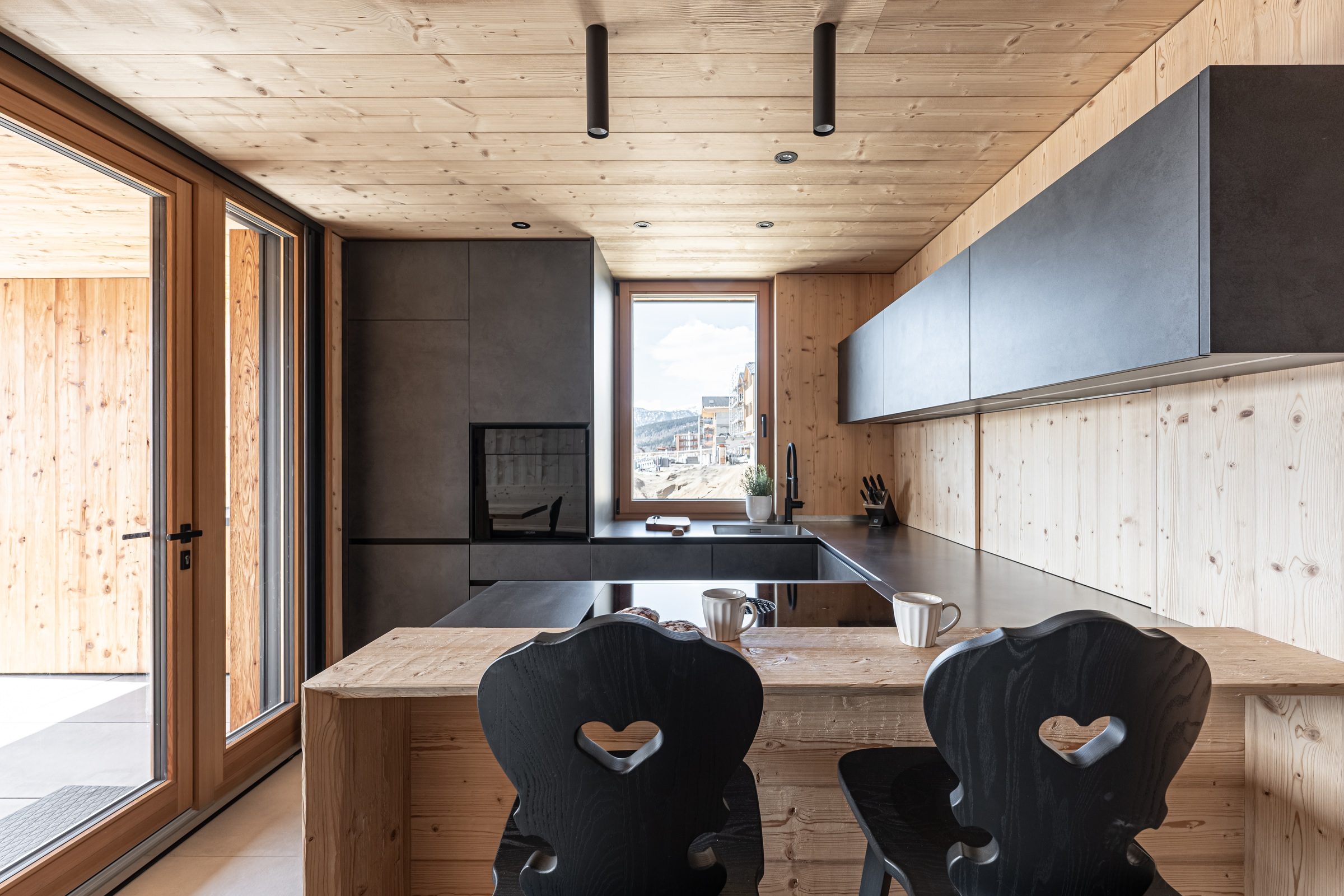 Holzküche mit schwarzen Fronten und Blick auf die Berge, Projekt in Meransen
